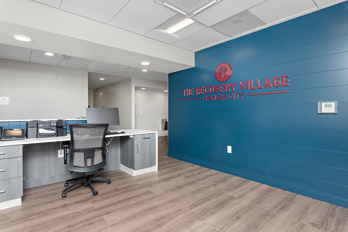 Rehab reception with desk and blue feature wall