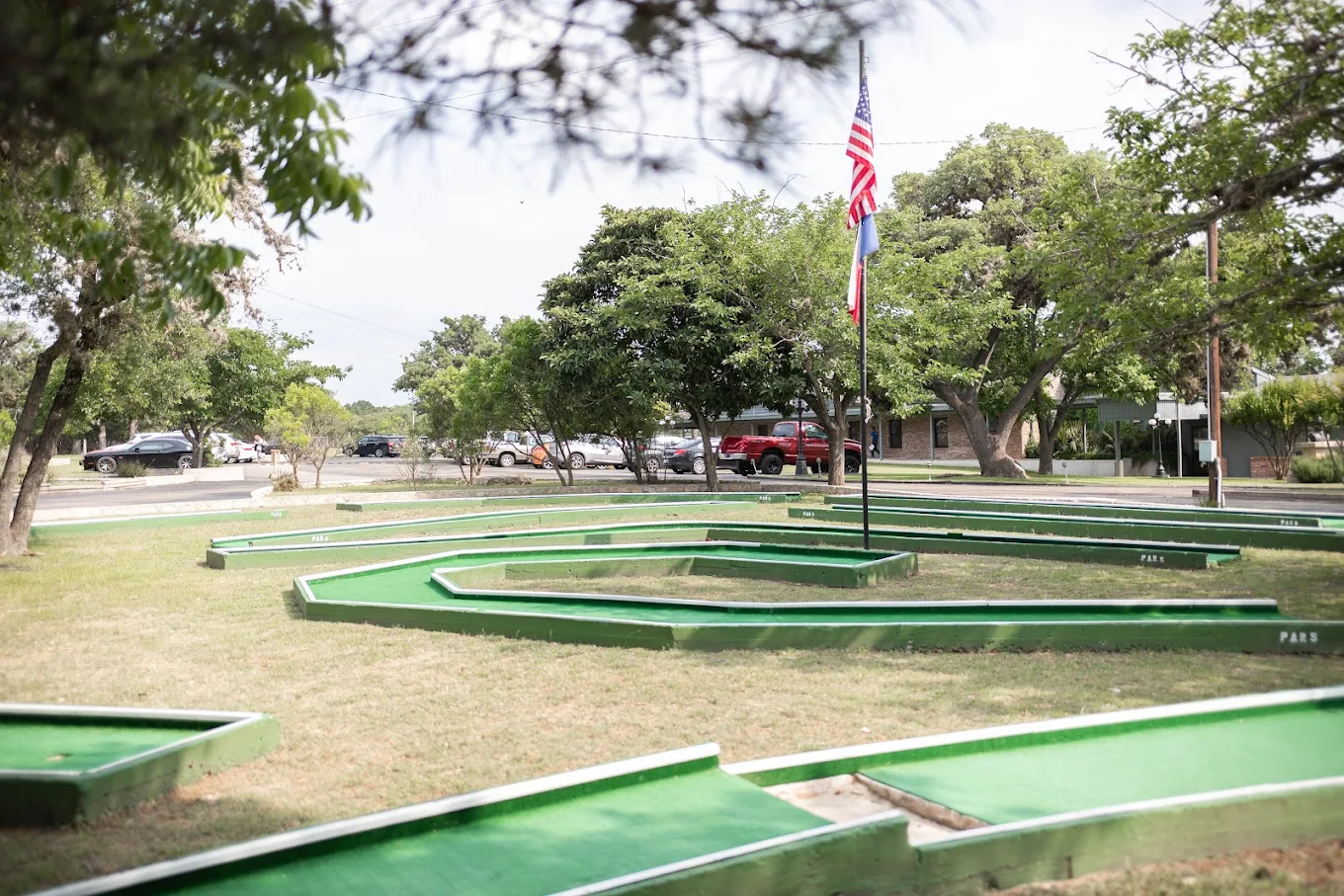 Mini-golf course with American flag in grassy courtyard