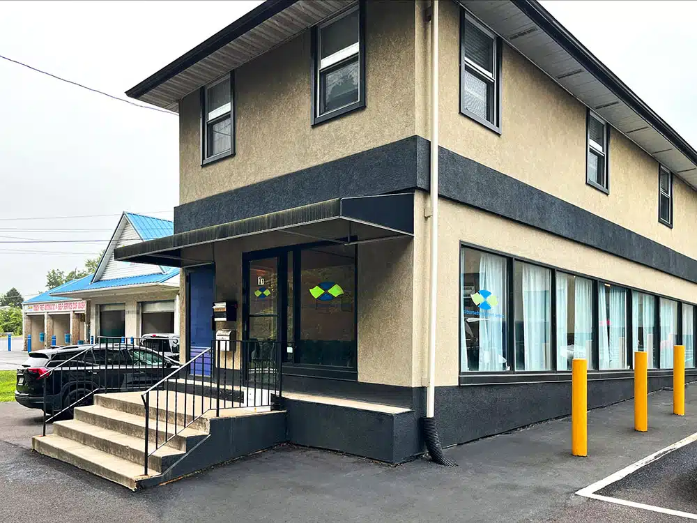 Two-story clinic building with entrance stairs and parking