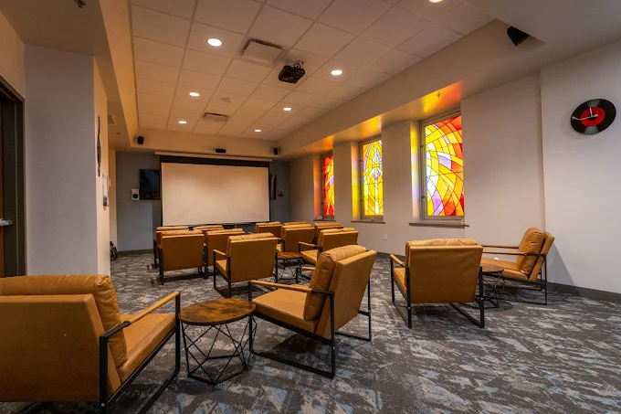 Group therapy room with chairs and stained glass windows