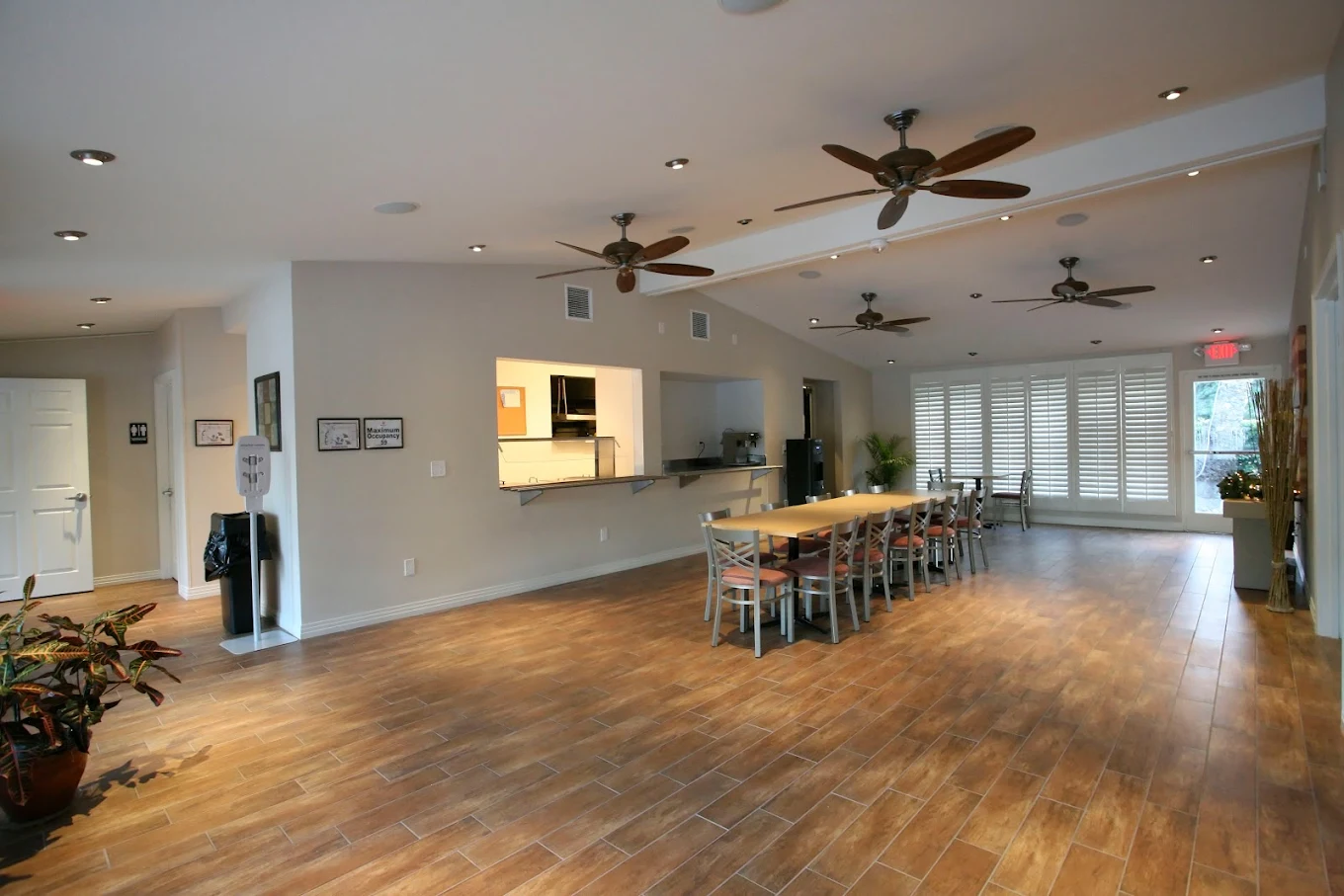 Spacious dining area with wooden flooring and ceiling fans