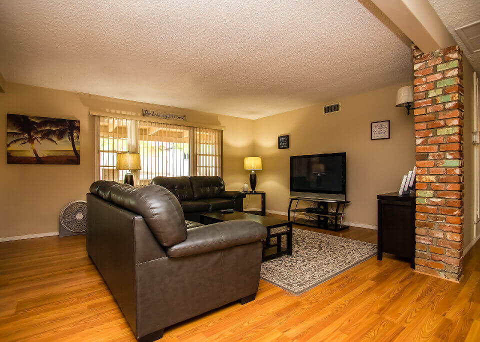 Cozy living room with dark leather sofas and a flat-screen TV