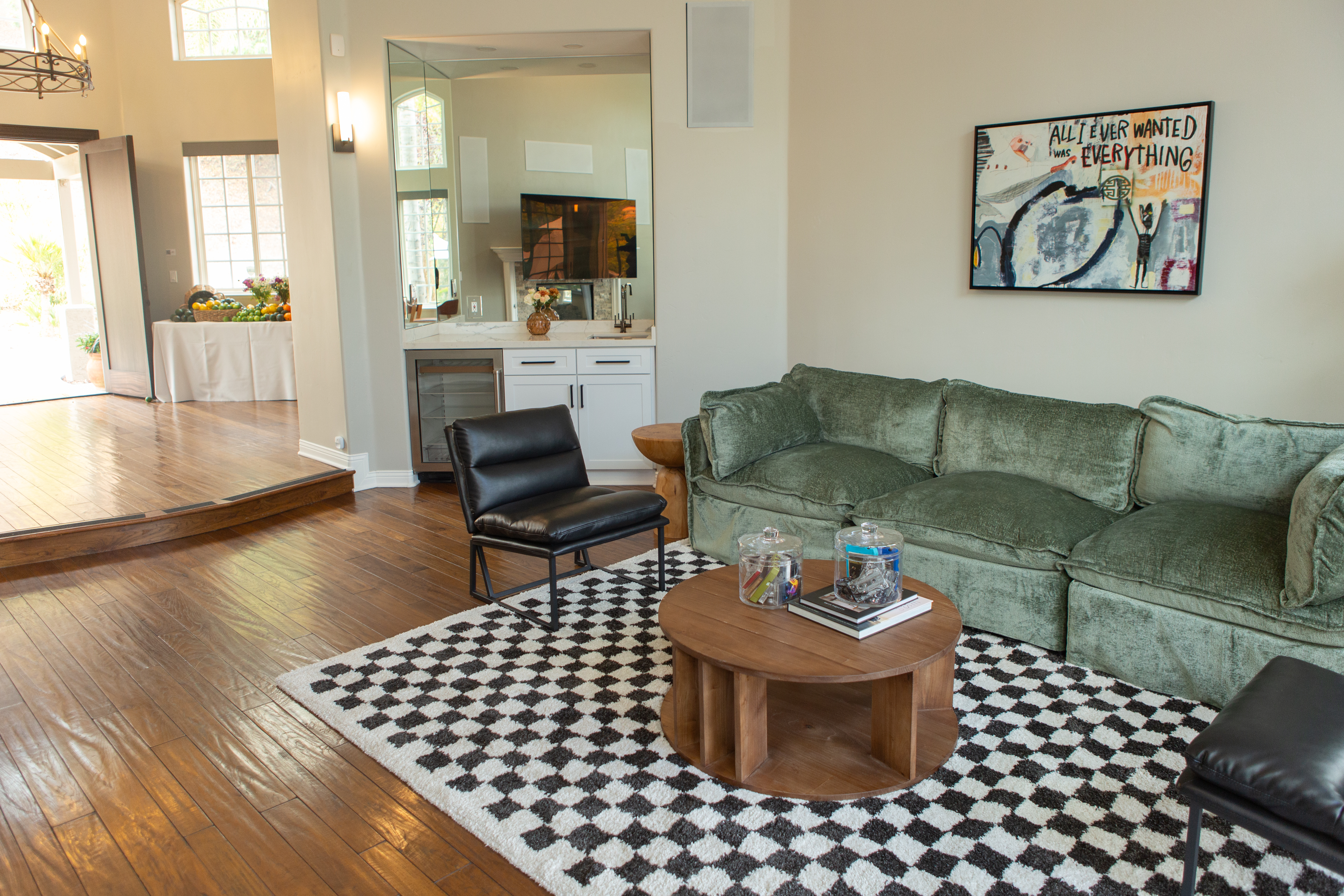 Green sofa, bar area, and checkered rug in lounge