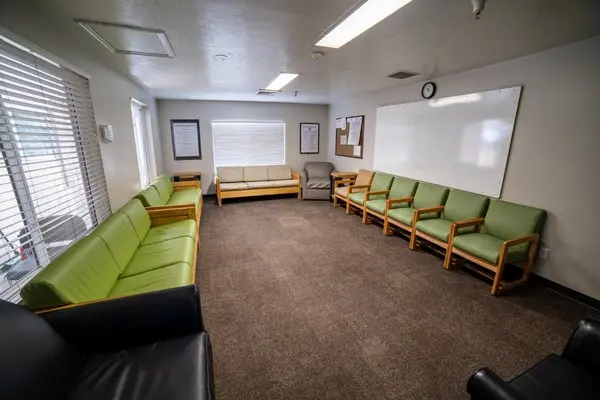 Spacious group room with green chairs and a whiteboard