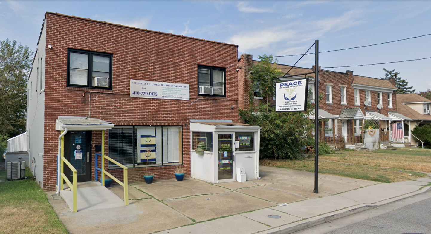 Brick two-story outpatient clinic with PEACE sign