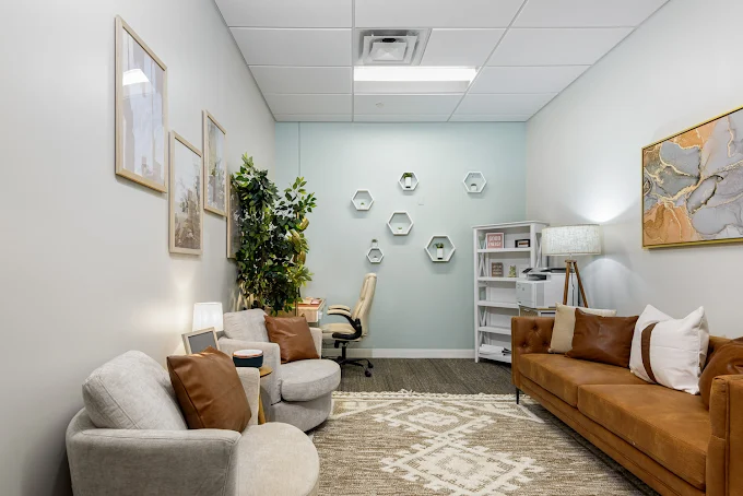 Therapy room with sofa, chairs, and desk