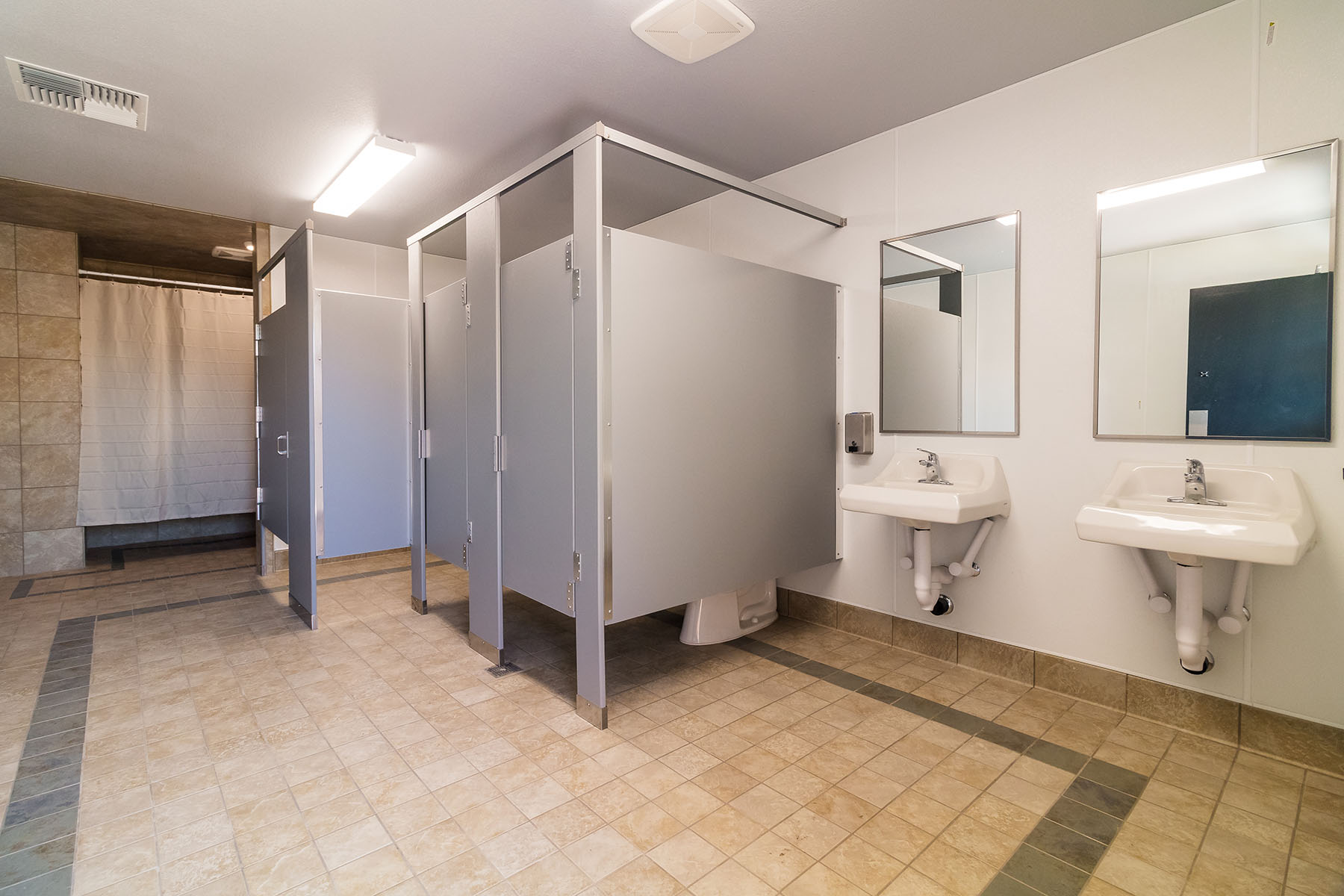 Shared bathroom with sinks and private stalls