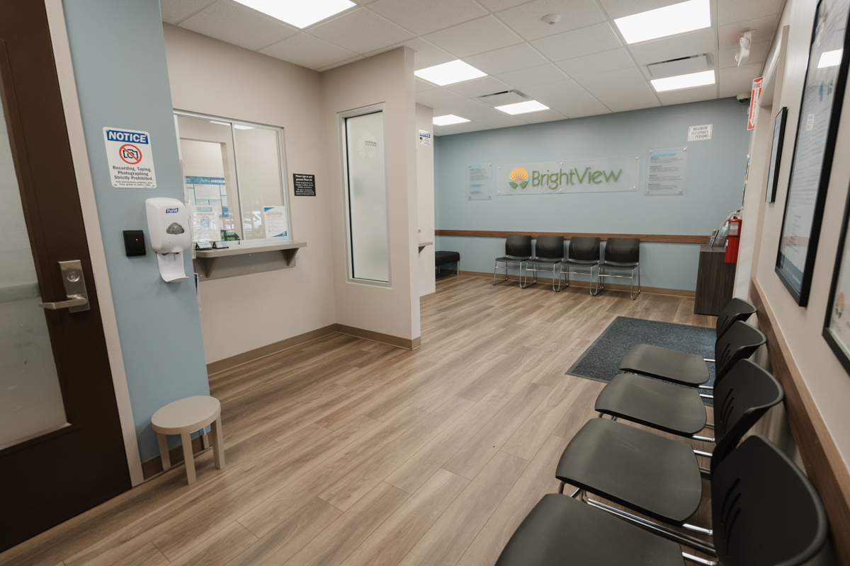 Patient waiting area with rows of chairs and service window