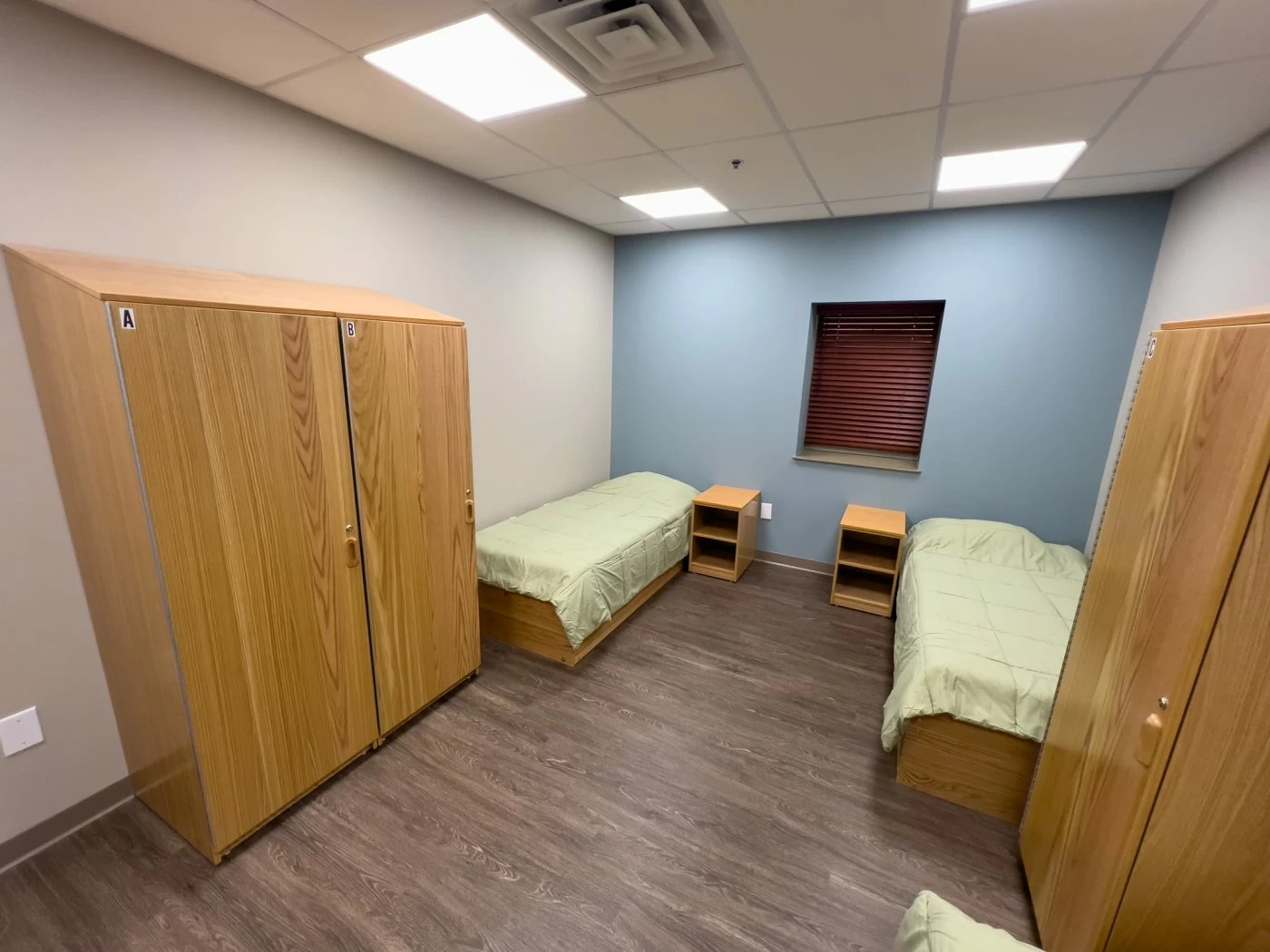 Shared residential bedroom with twin beds and storage cabinets at treatment center