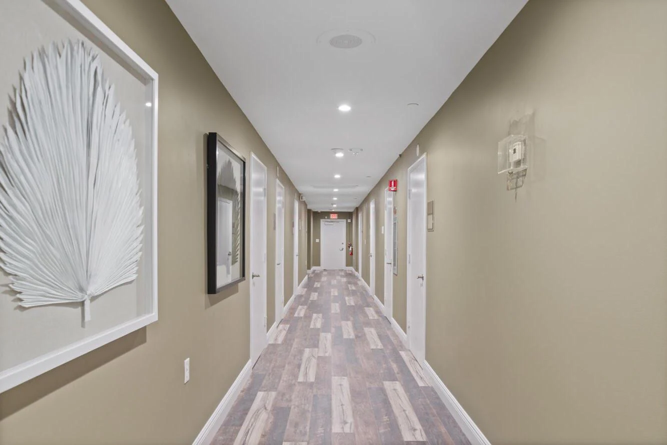 Hall with framed art and white doors on both sides