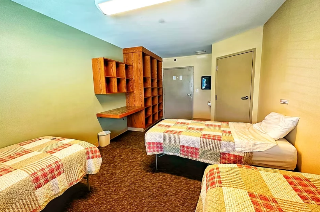 Shared bedroom with twin beds and wooden shelving