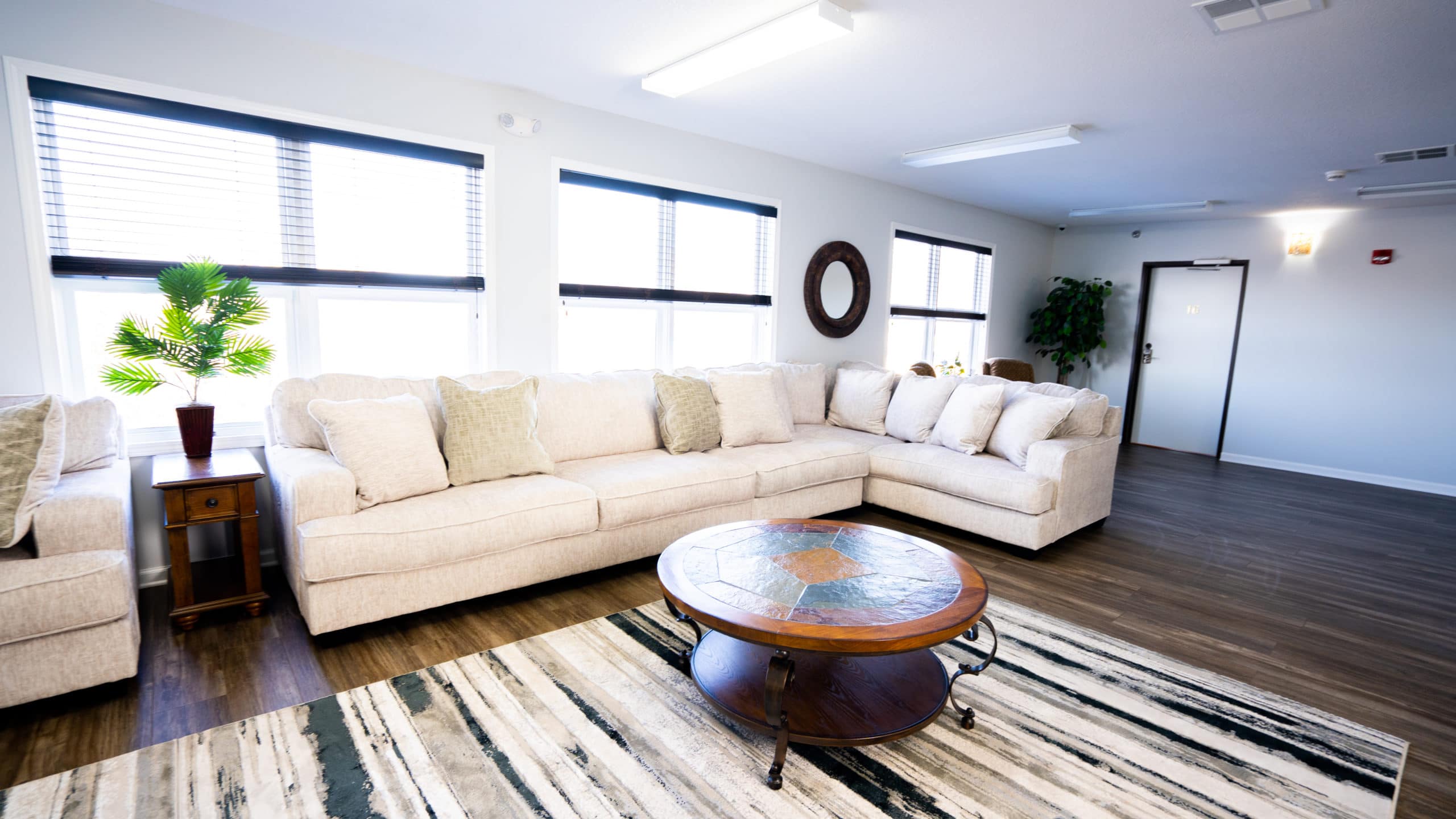 A spacious lounge with a sectional sofa and large windows.