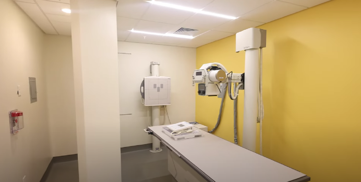 X-ray room with imaging equipment and exam table