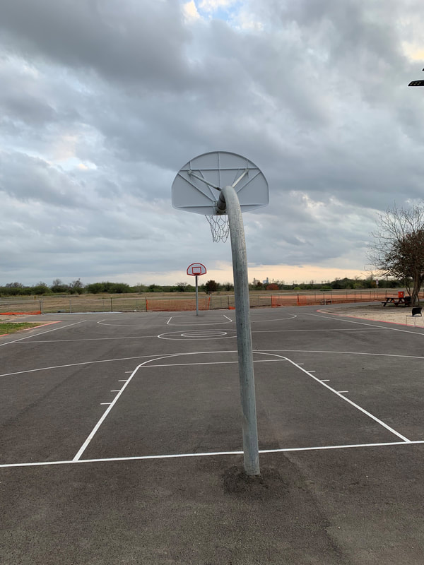 Outdoor basketball court with hoops and open sky