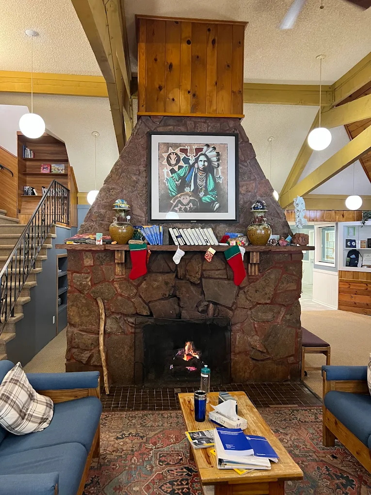 Cozy lounge with stone fireplace at Harmony Foundation