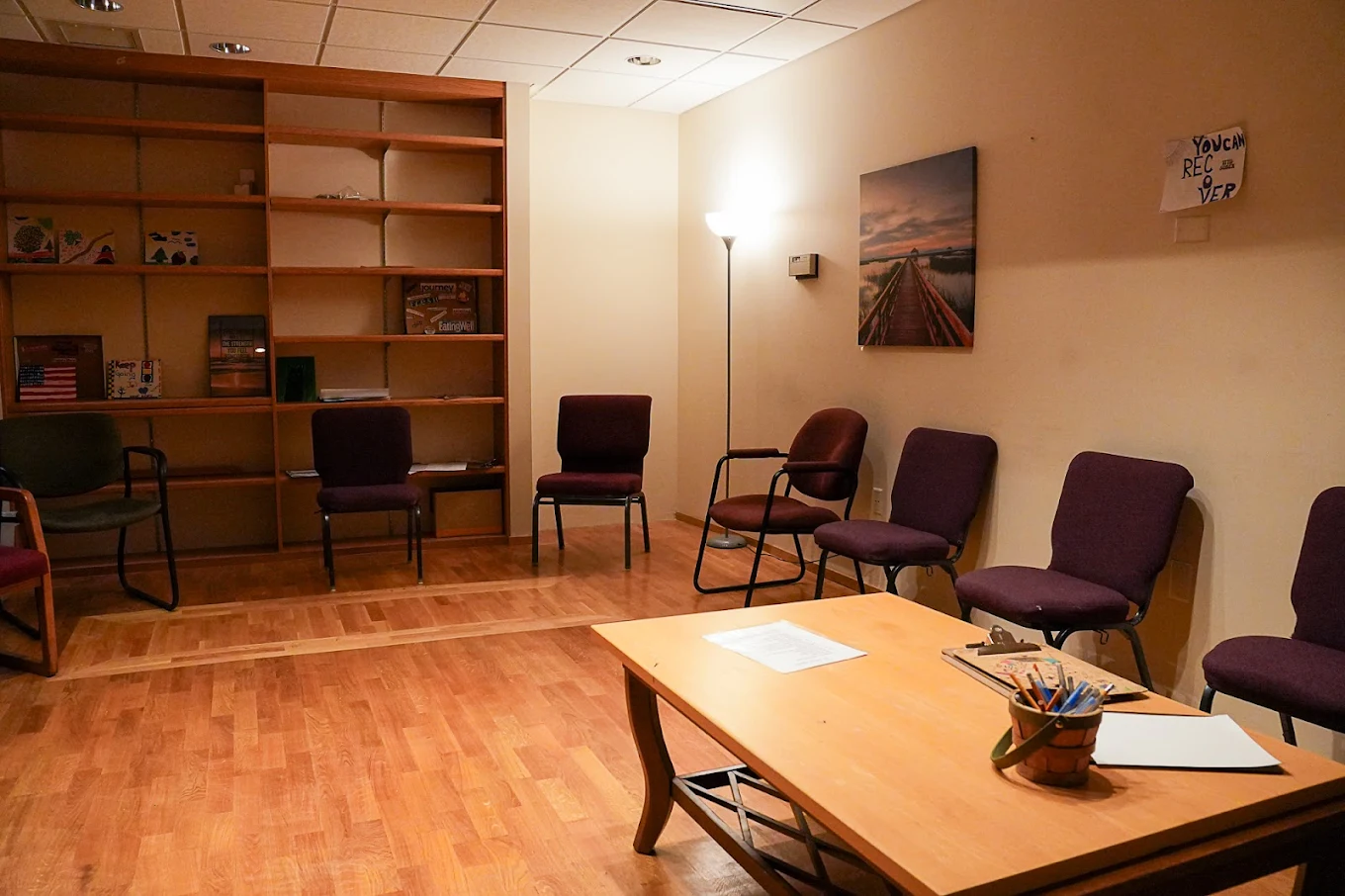 Circle of chairs and bookshelf in session room