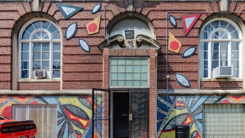 Brick entry with colorful mosaic art around door and windows