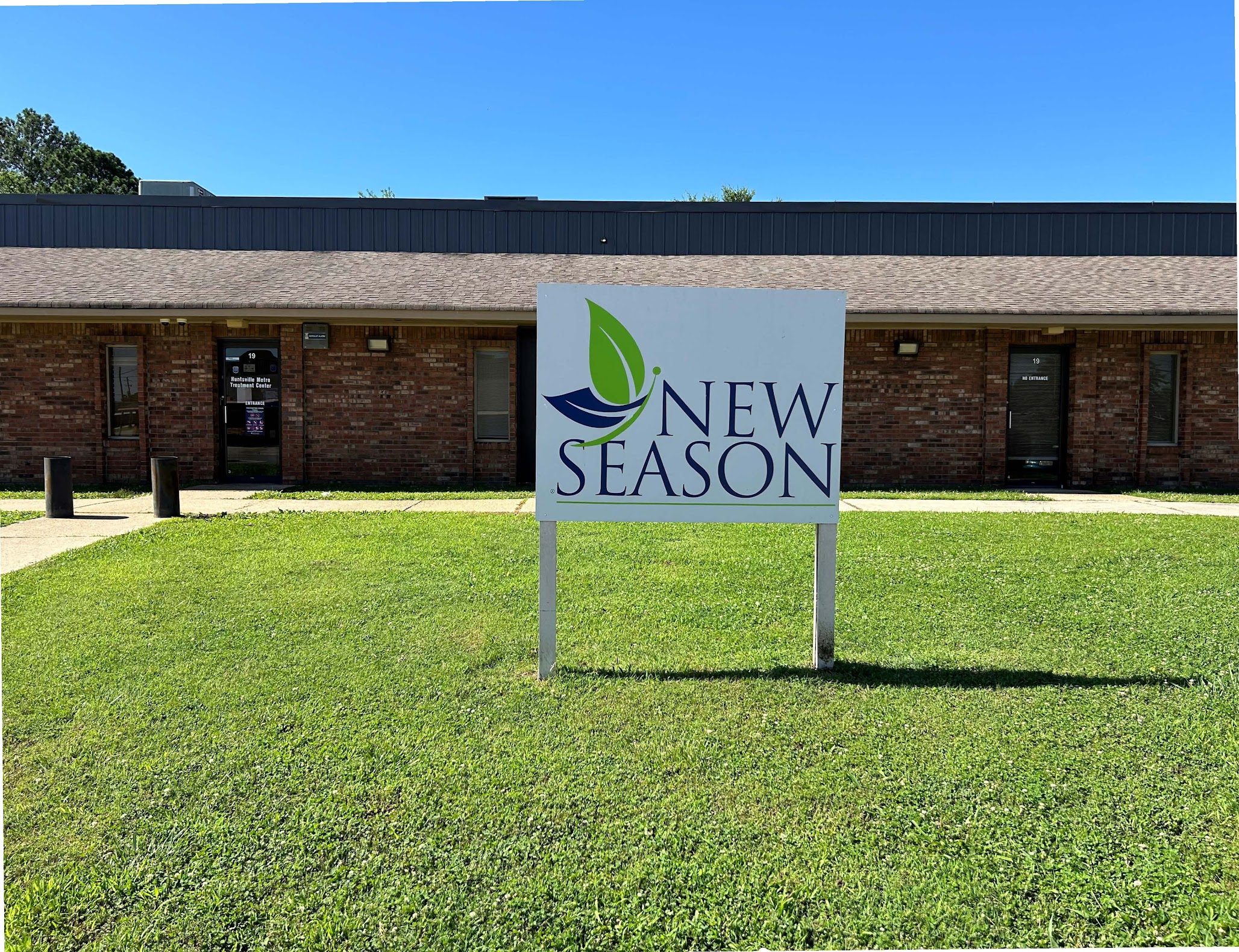New Season sign outside brick building on a sunny day