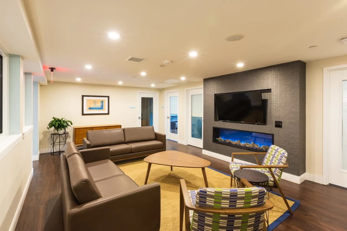 Lounge with couches, TV, and modern fireplace