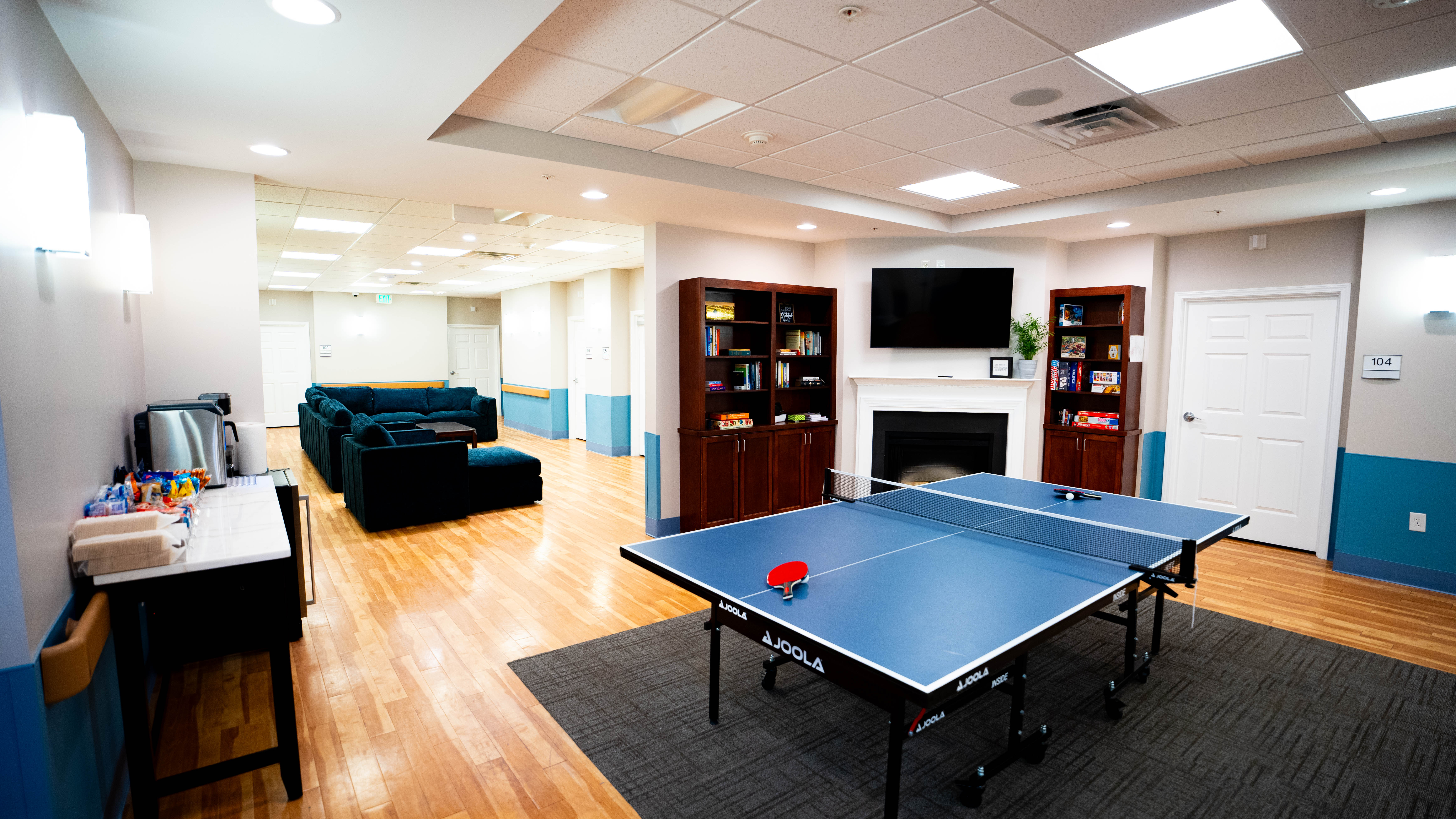  Common area with a ping pong table, bookshelves, and seating.