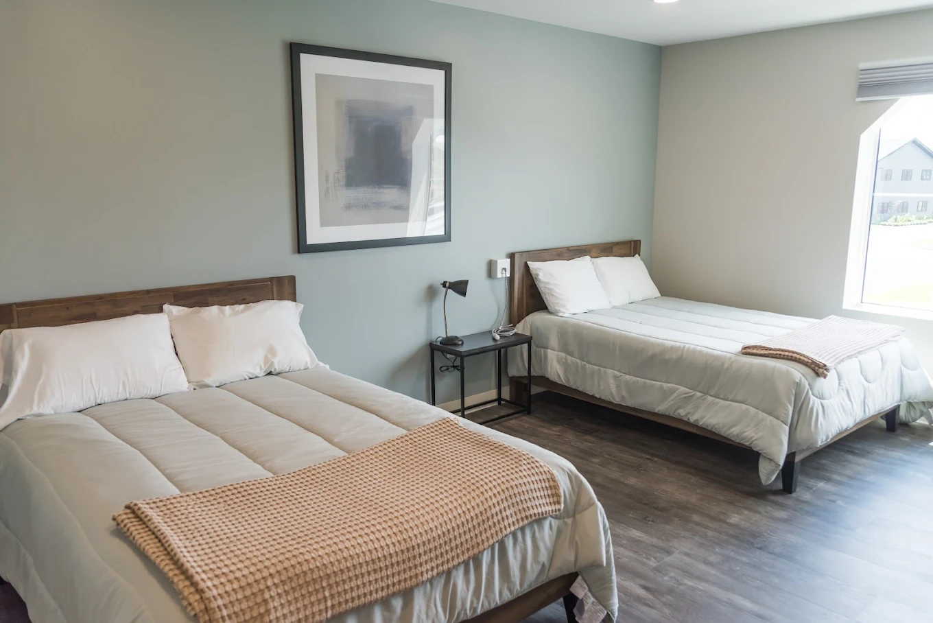 Two neatly made beds in shared rehab bedroom