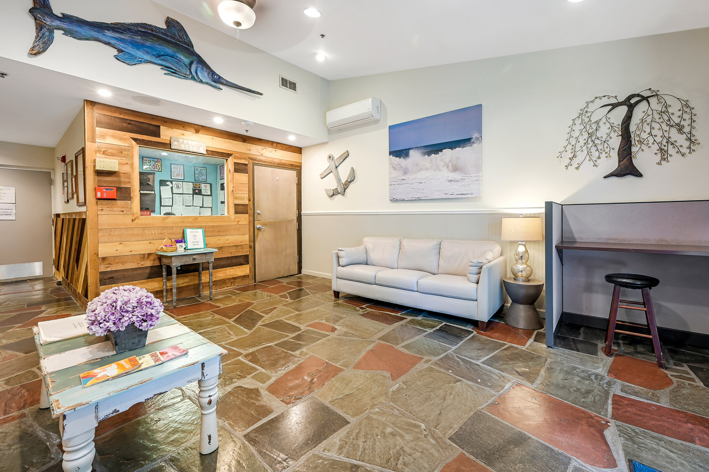 Cozy lounge with sofas, artwork, and natural stone flooring