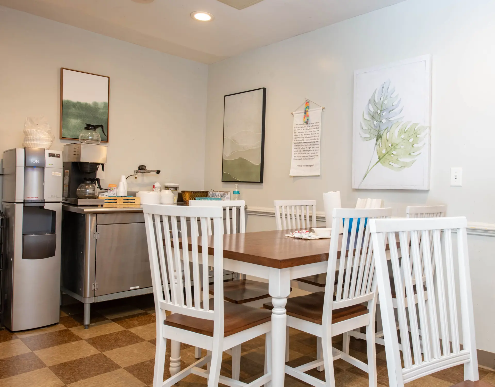Small dining space with white chairs and wooden table