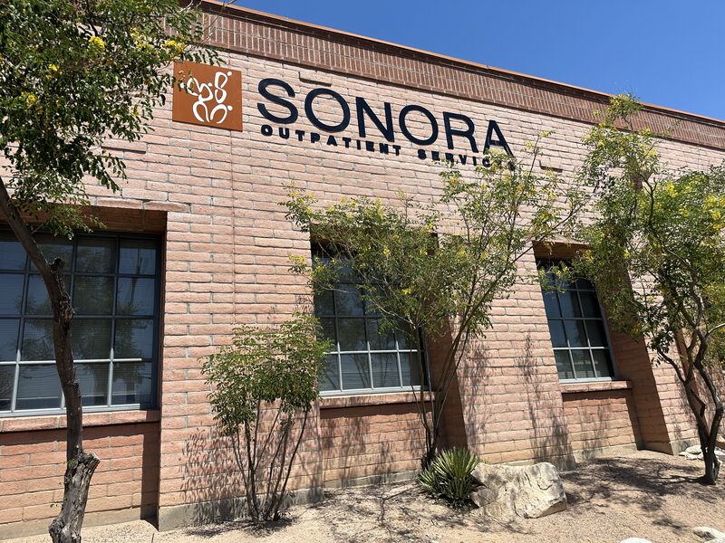 Brick building with trees and Sonora sign on wall