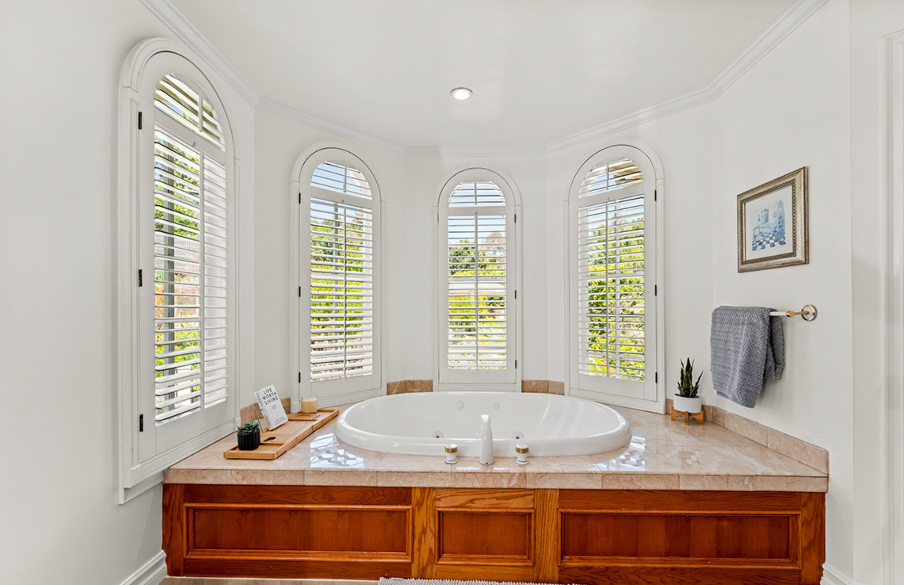 A bathroom with a large jacuzzi tub and arched windows.