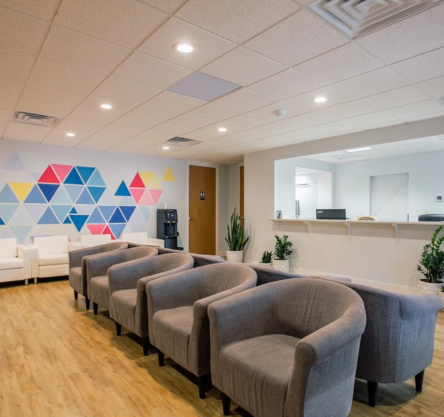 Reception waiting area with gray chairs and colorful wall art
