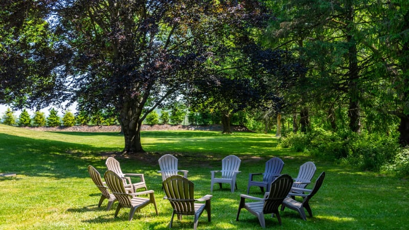 Outdoor common area with chairs arranged in a circle on the lawn.