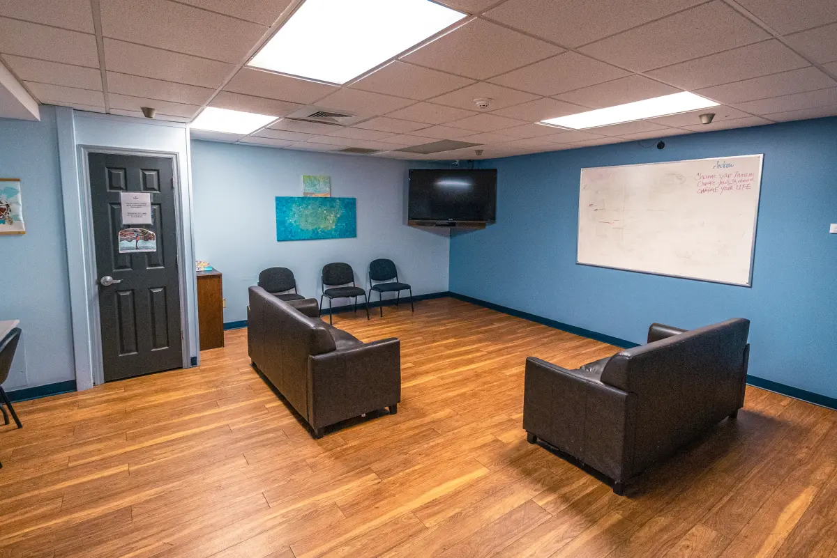 Therapy room with couches, chairs, and whiteboard