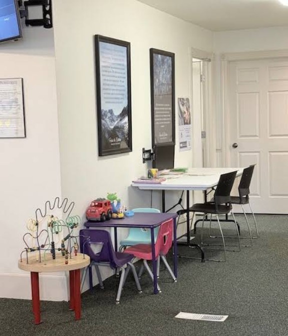 Indoor waiting area with chairs and activity table