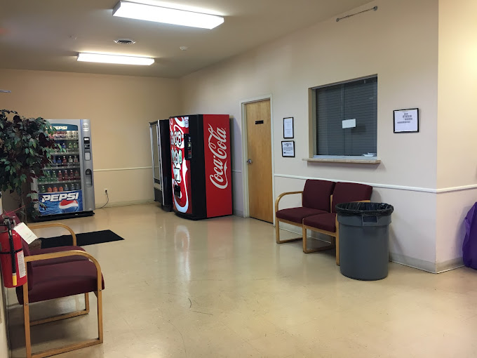 Waiting area with vending machines, chairs nesxt to reception.