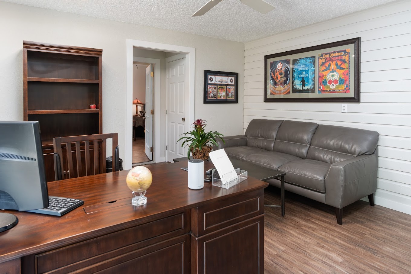Therapy room a desk, couch and a shelf.