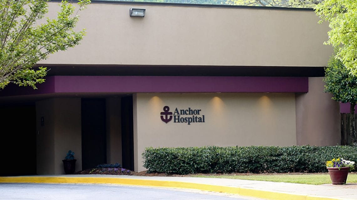 Exterior of Anchor Hospital with purple awning and logo
