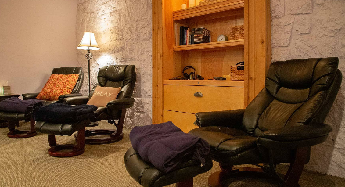 Cozy lounge with recliners, lamp, and blankets