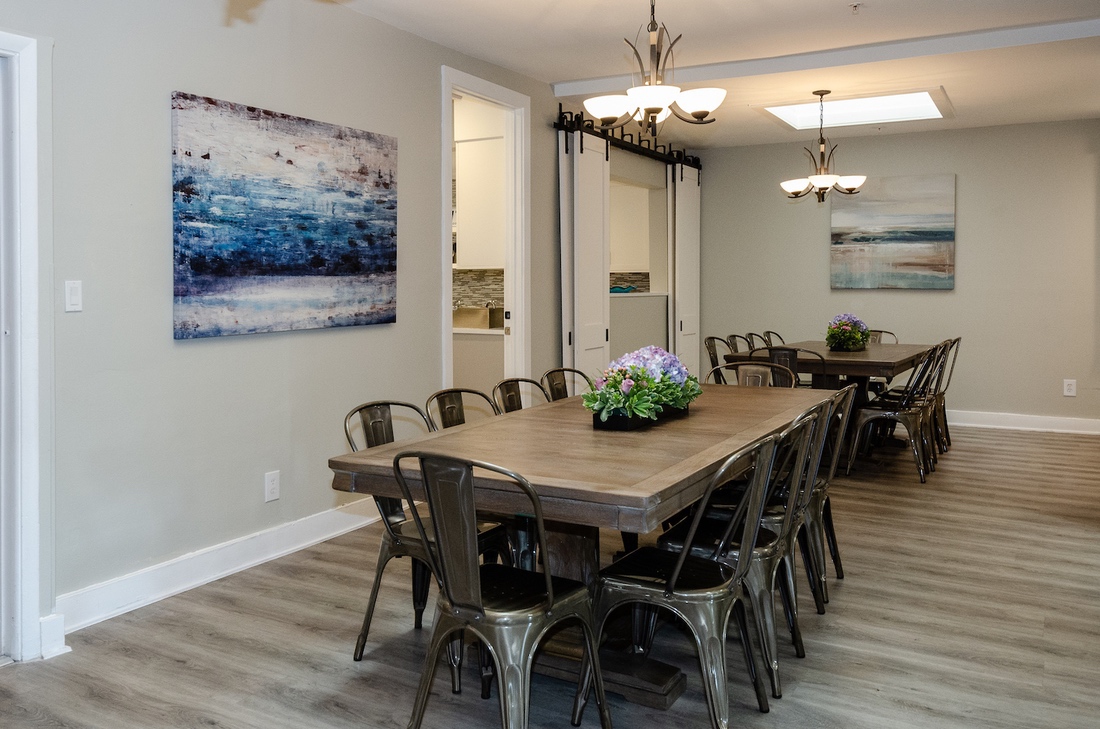 Dining room with long wooden tables and floral decor
