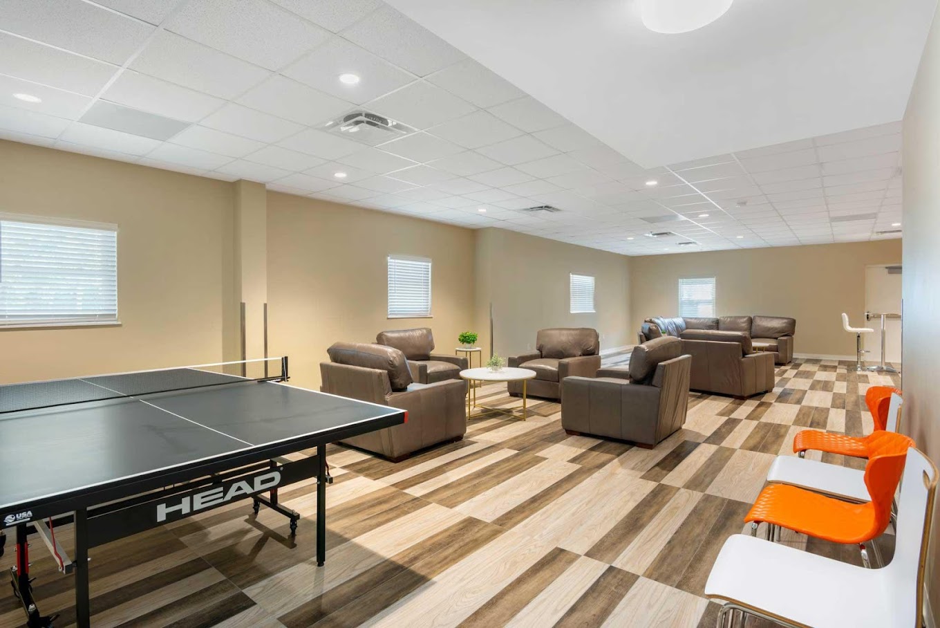 Recreation room with ping pong table and arraged couches.