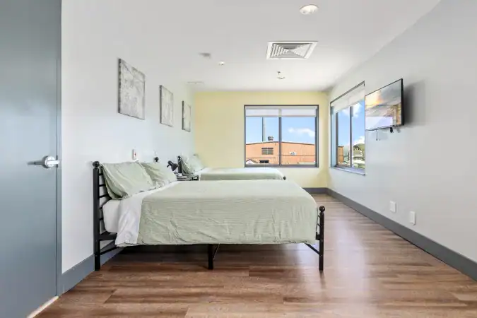 Shared bedroom with two beds and wide windows