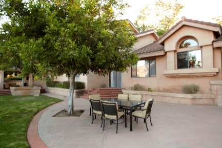 Outdoor patio with table and chairs under a tree