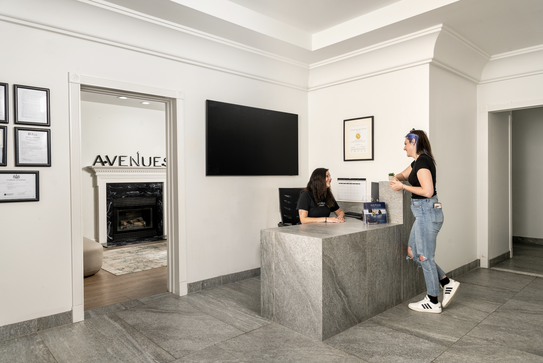 Staff greets client at marble reception desk