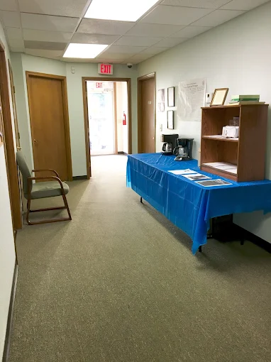 Front hall with table, shelves, and chairs near exit door