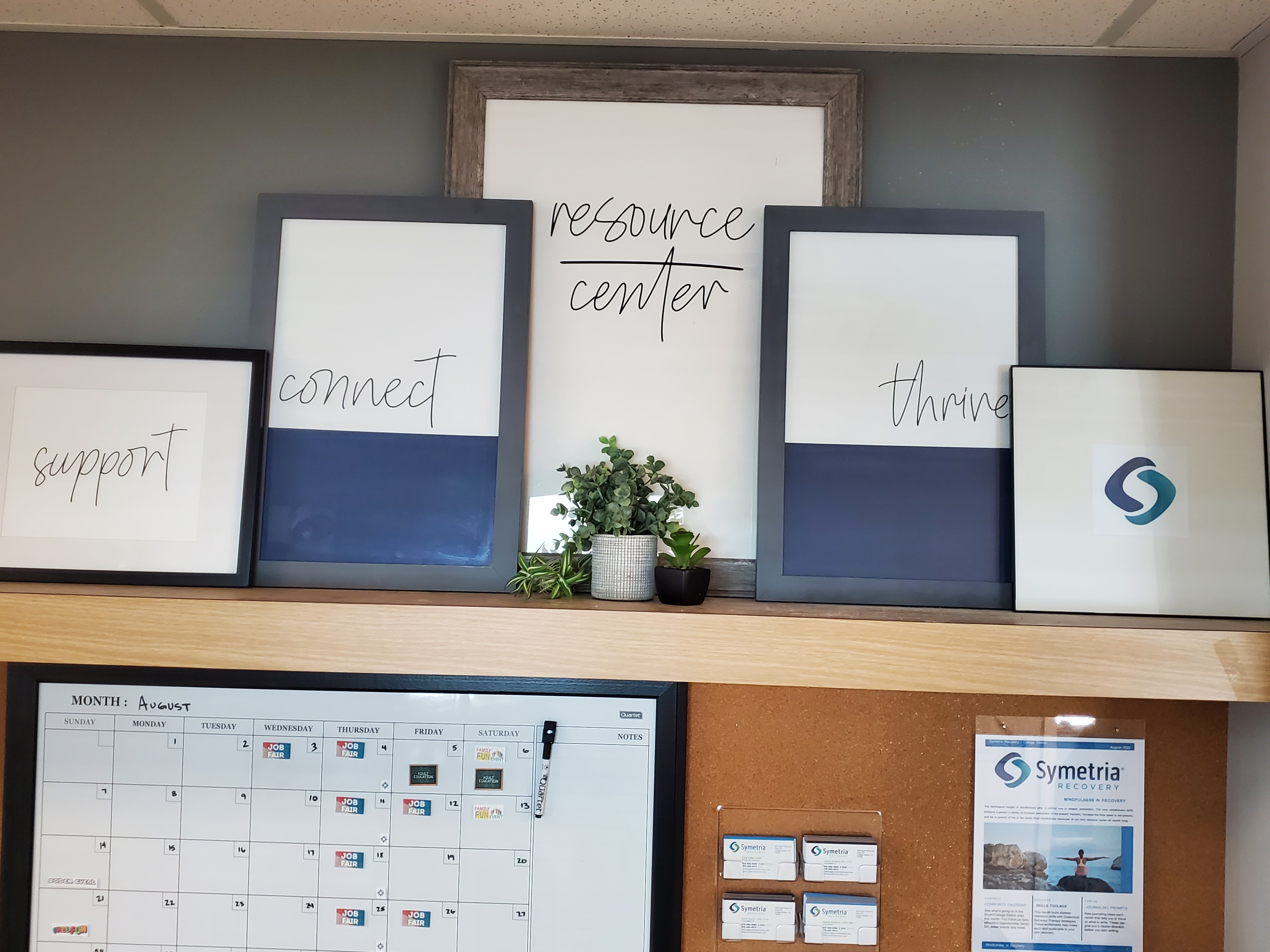 A resource center display with framed motivational words and a calendar.