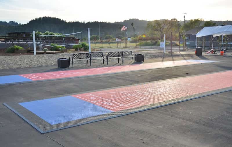 Outdoor shuffleboard court with seating and open grounds