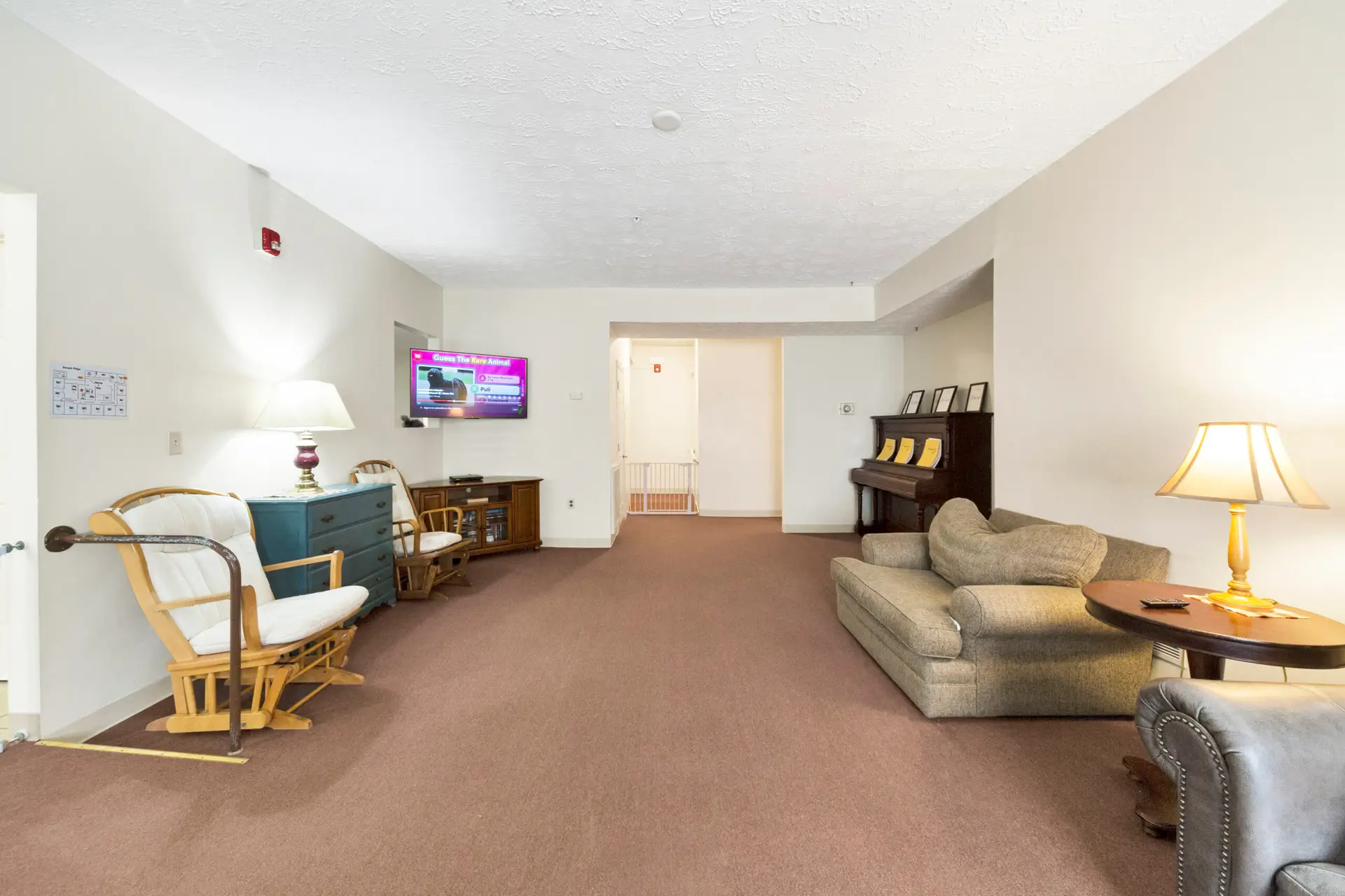 Lounge area with seating, piano, and wall-mounted TV