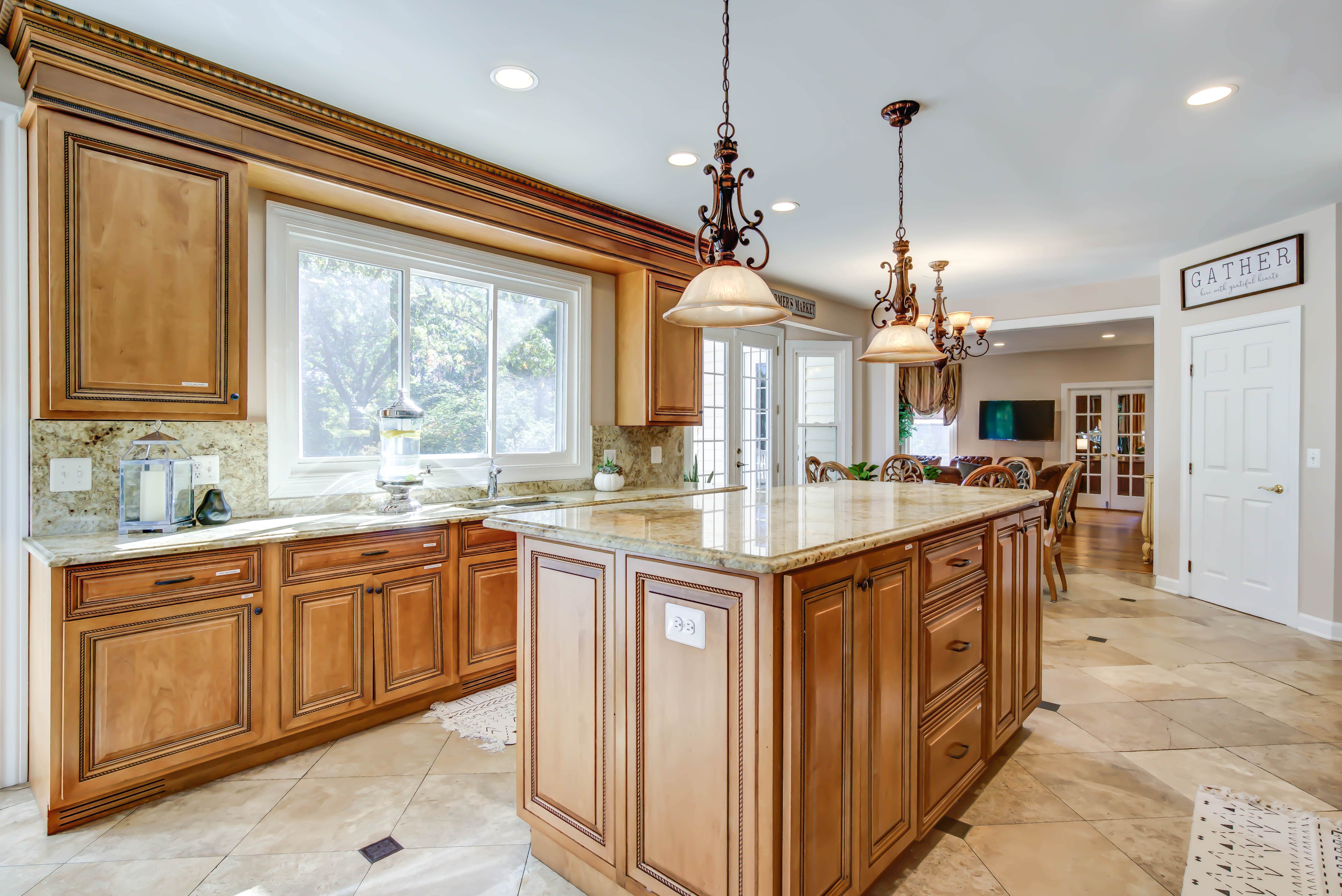 Large kitchen island with pendant lighting and wood cabinets