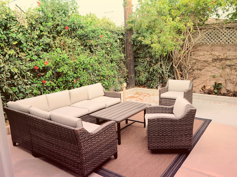 Outdoor patio with cushioned wicker seating.