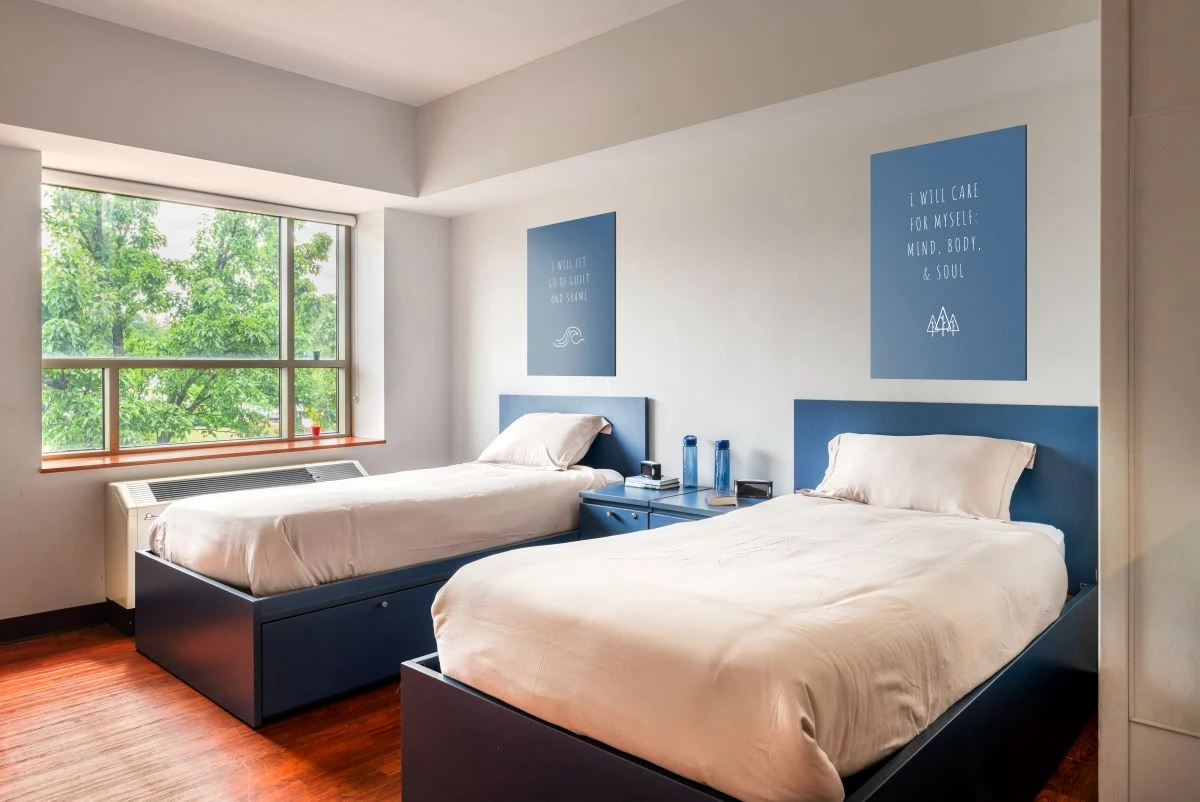 Bright double bedroom with large window and soft lighting