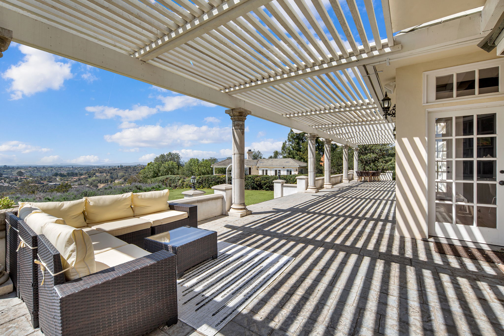 Covered patio area with seating overlooking landscape